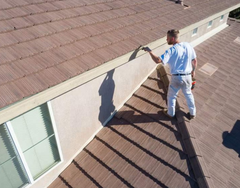 Roofing technician performing maintenance on a tile roof