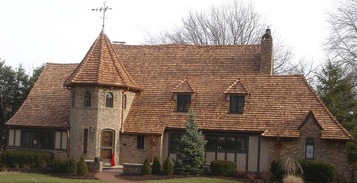 Large stone home with a multi-gable asphalt shingle roof